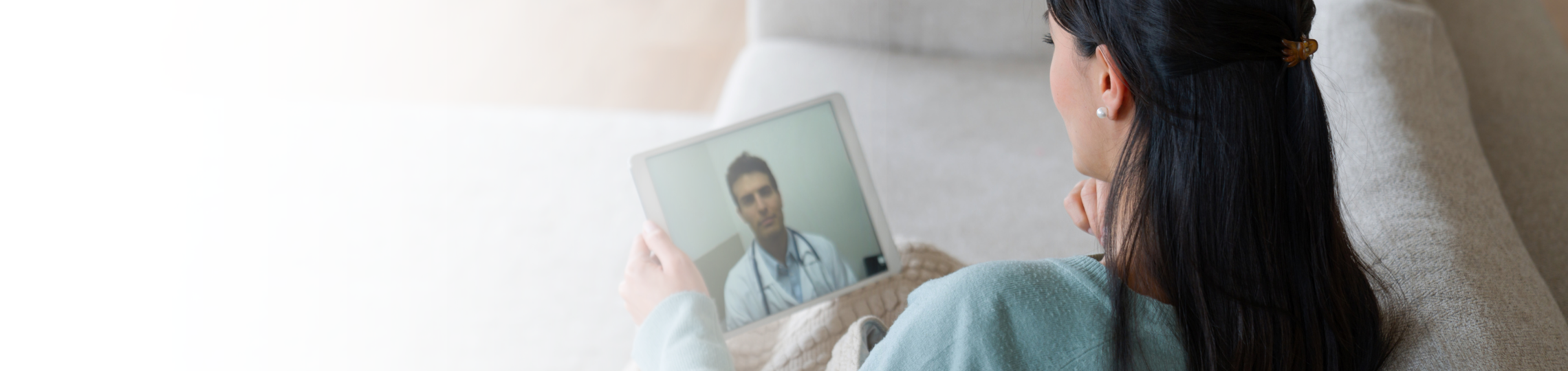 Woman on tablet talking to doctor virtually